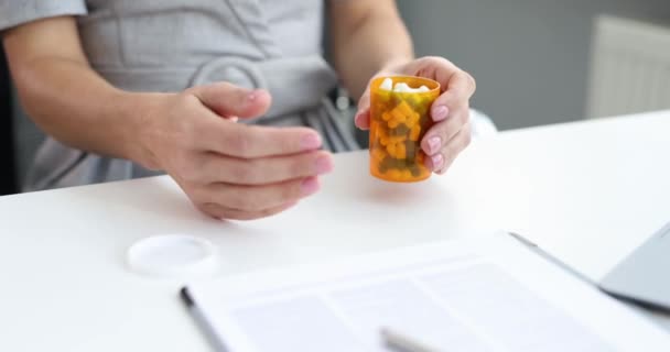 Mujer vertiendo muchas cápsulas de medicamentos en la palma de la mano en la oficina película 4k — Vídeo de stock