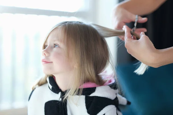 Kapper knippen haar van klein meisje in schoonheidssalon — Stockfoto