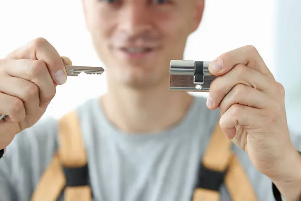 Um serralheiro mostra uma chave e uma fechadura, close-up — Fotografia de Stock