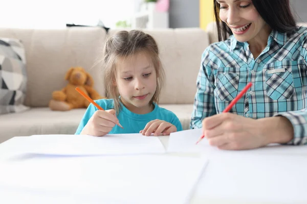 Anya és a kislánya otthon rajzolnak az asztalnál. — Stock Fotó