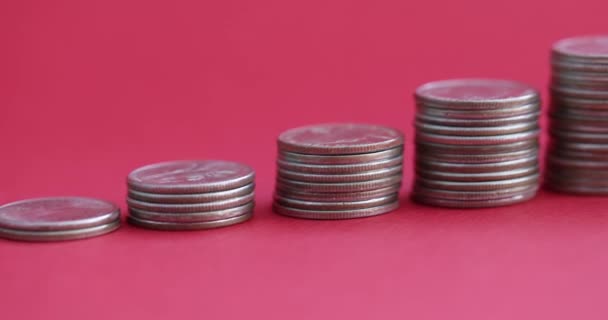 Stackar av mynt stigande med spargris bank på röd bakgrund 4k film — Stockvideo