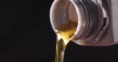Plastik şişe 4K filminden şeffaf sarı araba yağı akıyor.