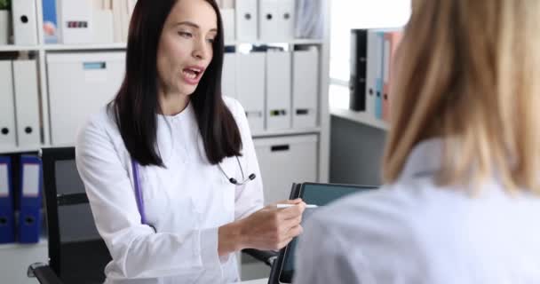 Le médecin montre une radiographie des poumons sur tablette au patient film 4k — Video