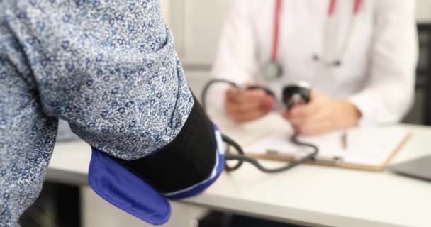 Médico que mide la presión arterial al paciente usando el tonómetro en la película clínica 4k — Vídeos de Stock