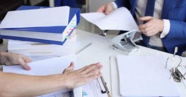 Belgeleri delgi zımba ve delikli zımba ile sıralayıp 4K klasörüne koyan kadın ve erkek.