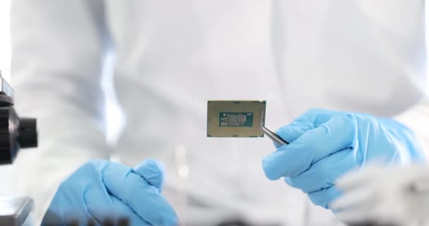 Hlavní opravář drží počítačový procesor s pinzetou v laboratoři 4k film zpomalený film — Stock video