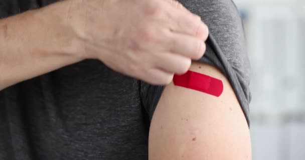 Uomo mostra patch rosso sulla spalla dopo essere stato vaccinato film al rallentatore 4k — Video Stock