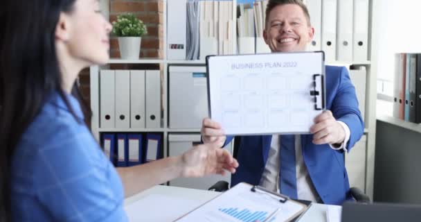 Geschäftsmann zeigt Businessplan für 2022 Geschäftsfrau lächelt und hält Daumen hoch Zeitlupe 4k Film