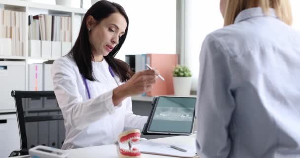 Dentista muestra paciente una radiografía de mandíbula sin diente en la tableta de cámara lenta 4k película — Vídeos de Stock