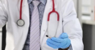 Klinikte elinde lastik eldivenlerle antiseptik tüttüren adam. 4K film yavaş çekim.