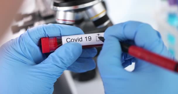 Medico mettendo risultato di analisi PCR su covid19 sulla provetta di sangue primo piano 4k film al rallentatore — Video Stock
