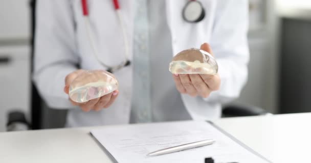 Cirujano plástico médico muestra silicona mama implante primer plano película 4k cámara lenta — Vídeo de stock