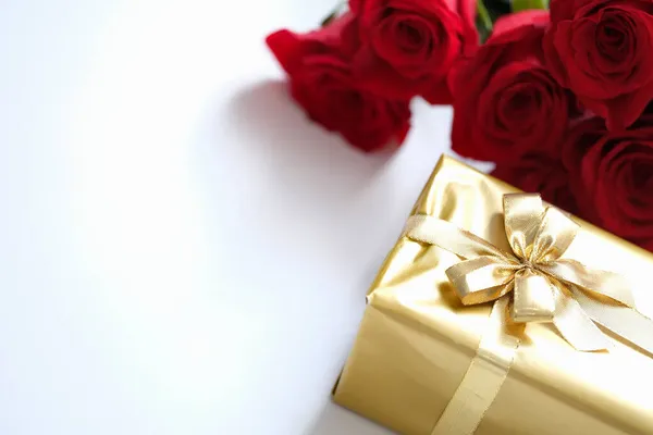 Όμορφα τυλιγμένο δώρο σε χρυσό χαρτί με κορδέλα — Φωτογραφία Αρχείου