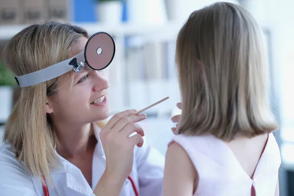 Enfant médecin regarde la gorge d'une petite fille — Photo