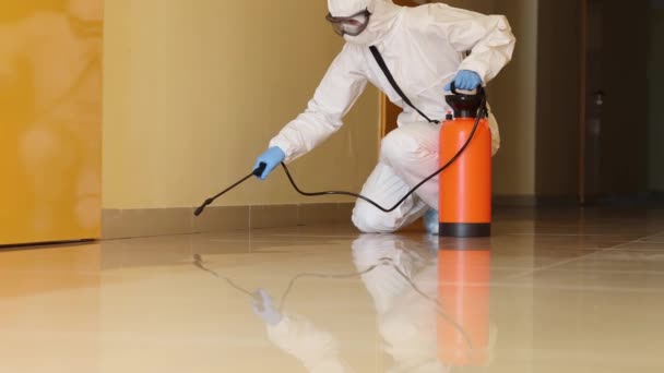 Desinfectante en traje protector tratando corredor de oficina con película antiséptica 4k cámara lenta — Vídeos de Stock