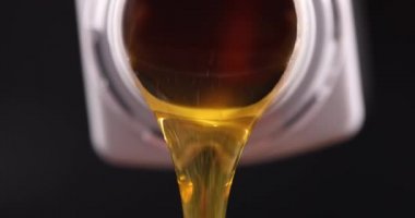 Plastik şişeden akan sarı motor yağı yakın çekim 4K film ağır çekim