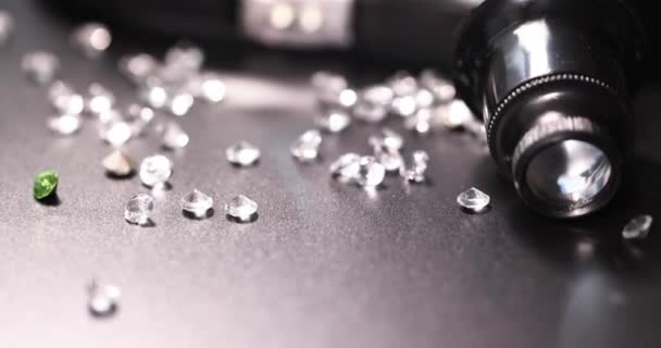 Jeweler magnifying glass lying among many scattered diamonds closeup 4k movie slow motion — Stock Video