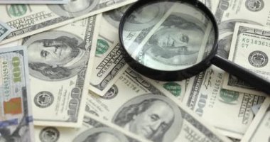 Bir sürü kağıt doların üzerinde büyüteç var. Yakın çekim 4K film yavaş çekim.