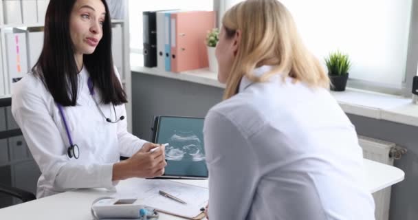Γιατρός γυναικολόγος δείχνει γυναίκα ασθενή υπερηχογράφημα του εμβρύου σε ψηφιακή ταμπλέτα 4k ταινία αργή κίνηση — Αρχείο Βίντεο