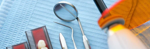 Instrumentos dentales y dentaduras postizas en la servilleta médica estéril en el primer plano de la clínica —  Fotos de Stock