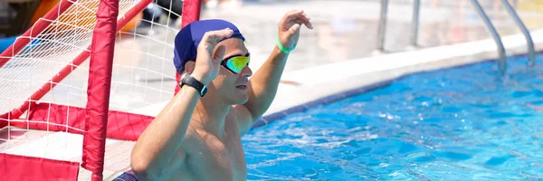 Jeune homme se tient à la porte dans la piscine jouant water polo gros plan — Photo