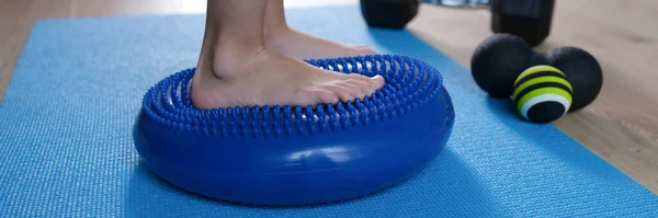 孩子的脚靠在蓝色按摩器平衡垫子特写上 — 图库照片