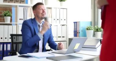 İş adamı telefonda konuşuyor. Meslektaşı içeri giriyor, belgeleri veriyor ve el sıkışıyor.