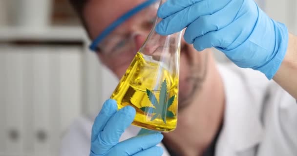 Científico con guantes agrieta vidrio de aceite de marihuana en laboratorio de cámara lenta 4k película — Vídeos de Stock