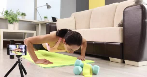 Jonge vrouw doen push-ups op tapijt thuis slow motion 4k film — Stockvideo