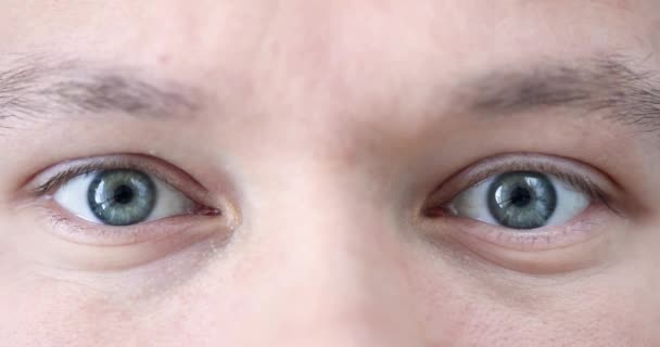Глаза молодого человека с серо-зеленым зрачком замедленной съемки 4К фильма — стоковое видео