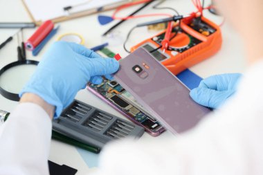 Master cep telefonunun kapağını atölyede kapatıyor.