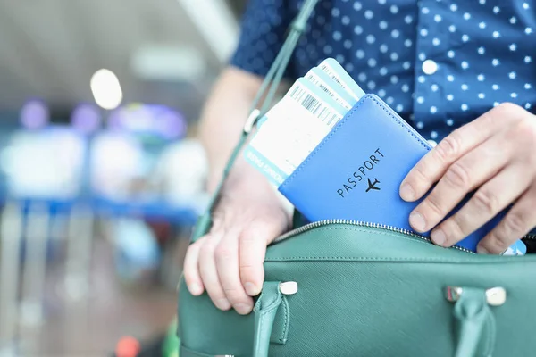 Hombre poniendo pasaporte con billetes de avión en la bolsa de ordenador portátil primer plano — Foto de Stock