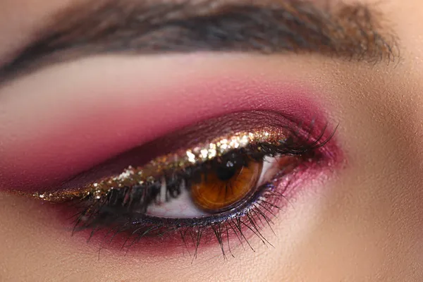 Zbliżenie kobiecego oka z jasnoróżowym makijażem — Zdjęcie stockowe