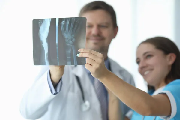 Artsen kijken naar röntgenfoto van de hand in kliniek closeup — Stockfoto