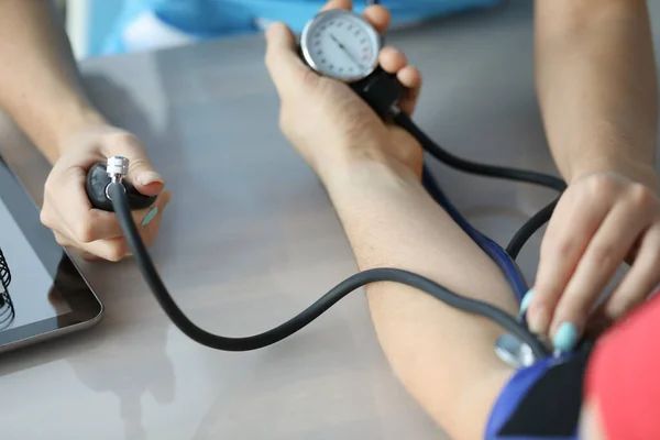 血圧計を使って腕の血圧を測定する医師 — ストック写真