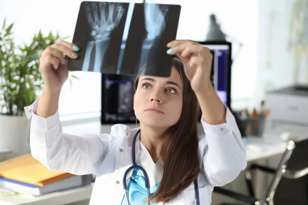 Femme médecin regardant la radiographie de la main dans le bureau de la clinique — Photo