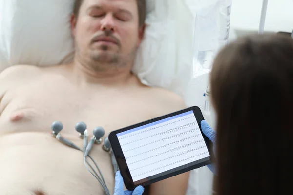 Orvos vesz kardiogram beteg beteg ember digitális tabletta a klinika közelkép — Stock Fotó