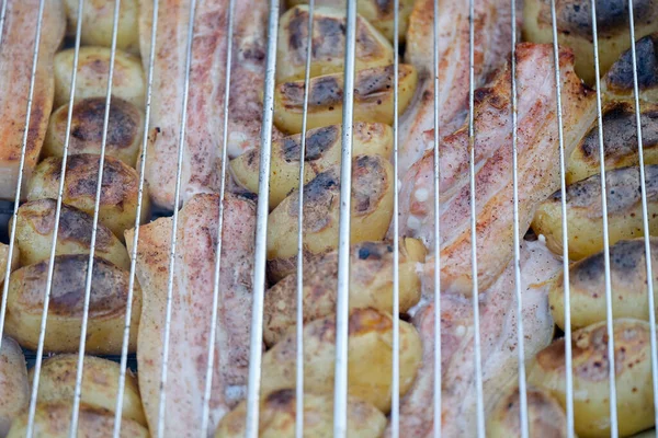Grill batatas e carne no fechamento do rack de arame — Fotografia de Stock