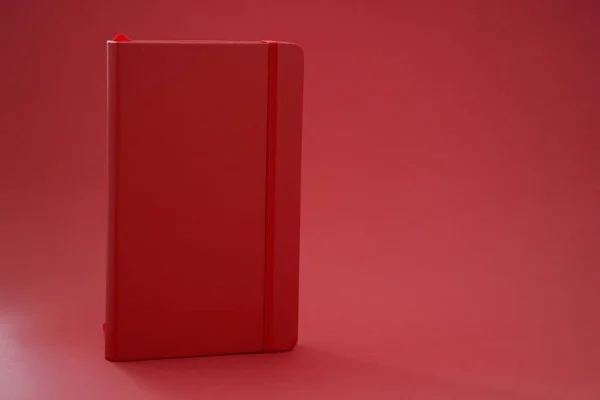 Livro de diário de couro vermelho no fundo vermelho — Fotografia de Stock
