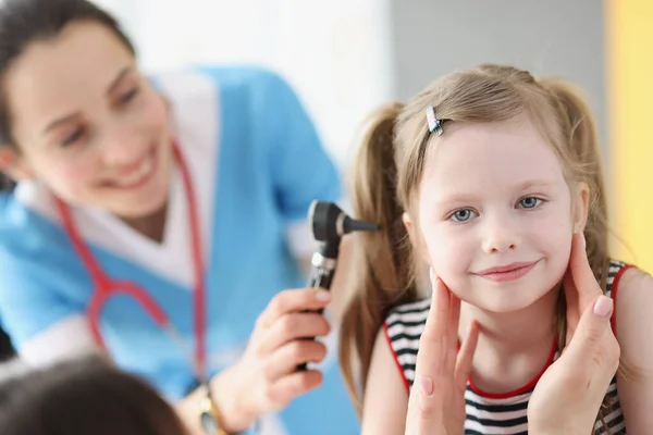 Жінка-лікар перевіряє здоров'я вух дівчат, крупним планом — стокове фото
