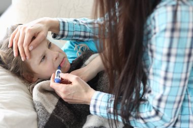 Ağzında termometreyle annem yakınlarda.