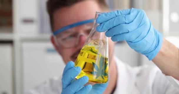 Adam bilim adamı kimyager, matara içinde sarı marihuana yağını sallıyor. — Stok video