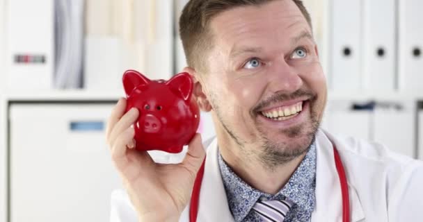 Úspěšný lékař třese červeným prasečím břehem u ucha 4k film zpomalení — Stock video