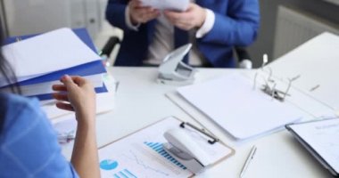 Belgeleri zımba ve delikli zımba ile sıralayan adam ve kadın dizinlere 4k film ağır çekim