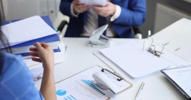 Man and woman sorting documents with stapler and hole punch and folding into folders 4k movie slow motion — Stock Video