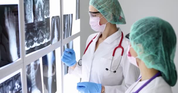 Arzt mit Brille und Maske schaut Röntgenbild der Lungen in Klinik an — Stockvideo