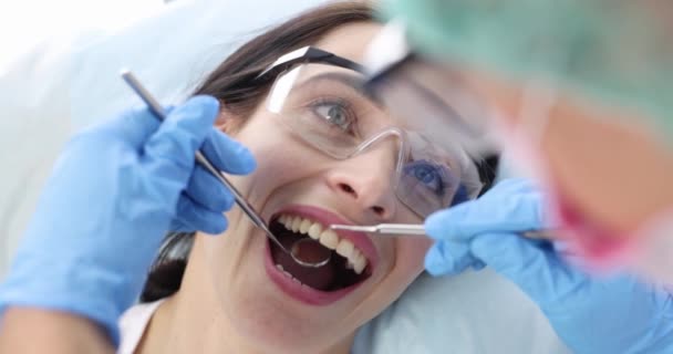 강철 도구를 사용하여 여성 환자 의이를 검사하는 치과 의사 4k 영화 슬로우 모션 — 비디오