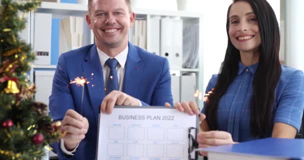 Man en vrouw zwaaien met sterren en het houden van documenten met business plan voor 2022 4k film slow motion — Stockvideo