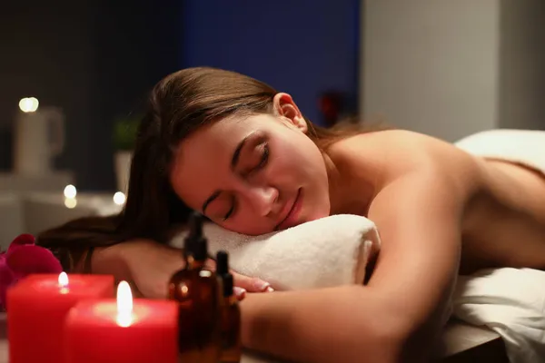 Jeune femme allongée les yeux fermés sur une table de massage au spa — Photo