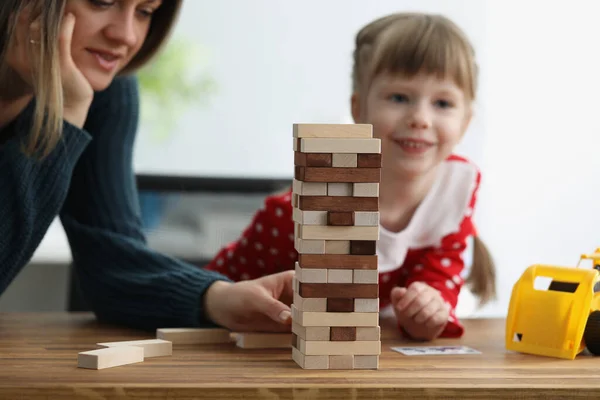 Lycklig mor med barn flicka spelar träklossar torn hemma — Stockfoto